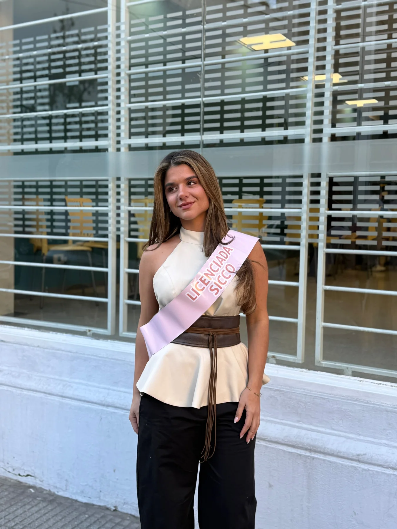 Majo recibida, con la banda de egresada en la puerta de la Universidad de Palermo